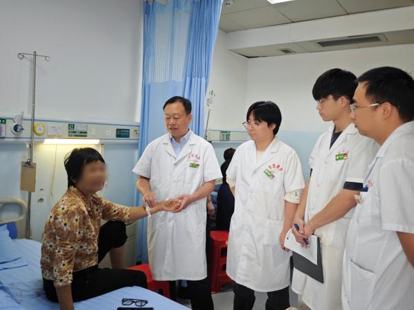 黄勇平教授(左二)带领团队查看患者恢复情况。王瑞文 摄 黄勇平教授(左二)带领团队查看患者恢复情况。王瑞文 摄