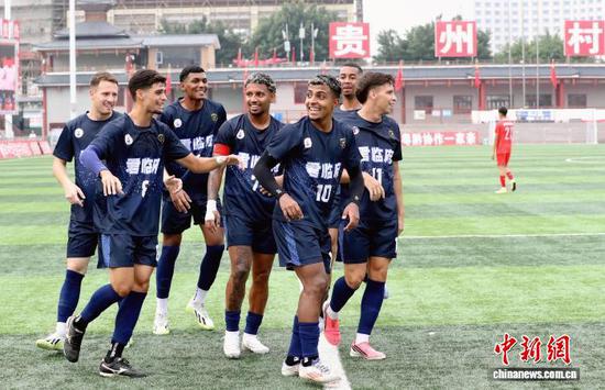 图为10月1日,巴西银河联足球队球员(藏青色球衣)进球后聚集在一起庆祝。李长华 摄 图为10月1日,巴西银河联足球队球员(藏青色球衣)进球后聚集在一起庆祝。李长华 摄