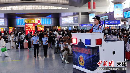 图为北京铁路公安局天津公安处天津站派出所民警正在候车室巡逻，瞭望台上民警正在执勤，维护好候车室内旅客出行秩序。（北京铁路公安局天津公安处供图）