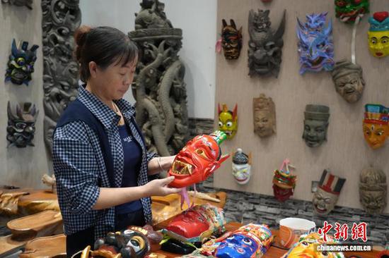 图为游客在观赏傩戏面具。石小杰 摄 图为游客在观赏傩戏面具。石小杰 摄