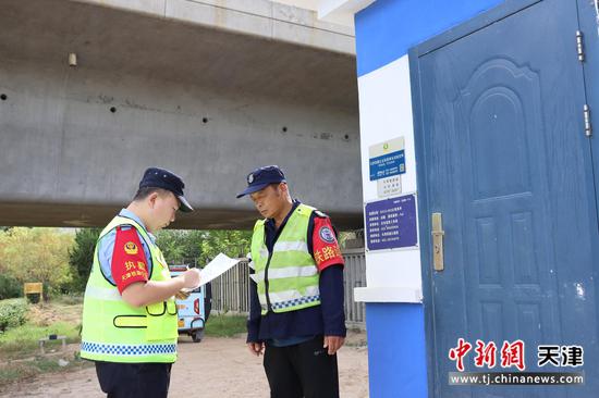 图为北京铁路公安局天津公安处线路民警与护路保安交谈，检查线路安全，防止隐患发生。（北京铁路公安局天津公安处供图）