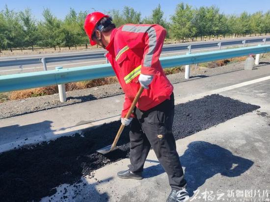 9月30日，养护人员在处理路面坑槽病害。高爱英摄f