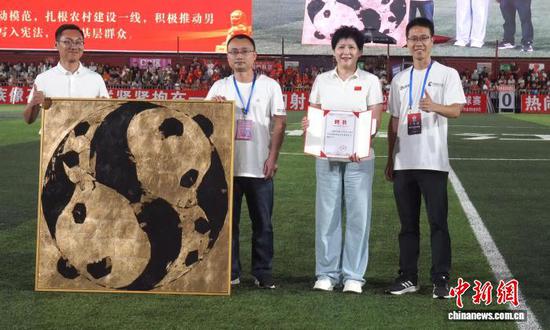 图为10月1日晚,魏心田(左三)赠送《金色两仪》作品现场。榕江融媒供图 图为10月1日晚,魏心田(左三)赠送《金色两仪》作品现场。榕江融媒供图