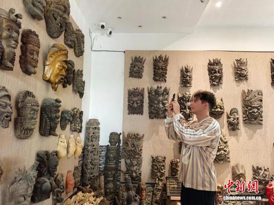 图为俄罗斯游客爱德在拍摄傩戏面具。石小杰 摄 图为俄罗斯游客爱德在拍摄傩戏面具。石小杰 摄