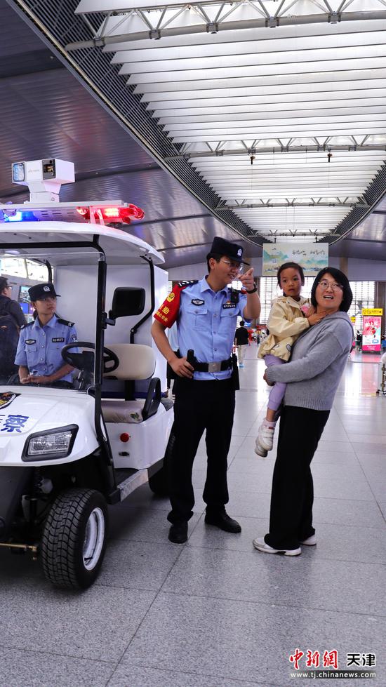 图为北京铁路公安局天津公安处天津站派出所民警正在候车大厅为旅客指路。（北京铁路公安局天津公安处供图）