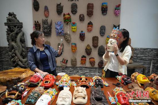 图为游客在体验傩戏面具。石小杰 摄 图为游客在体验傩戏面具。石小杰 摄