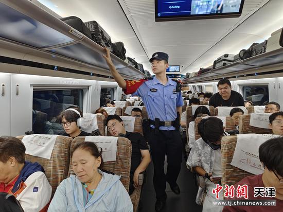 图为北京铁路公安局天津公安处乘警支队民警正在车厢内巡视，排除安全隐患。（北京铁路公安局天津公安处供图）