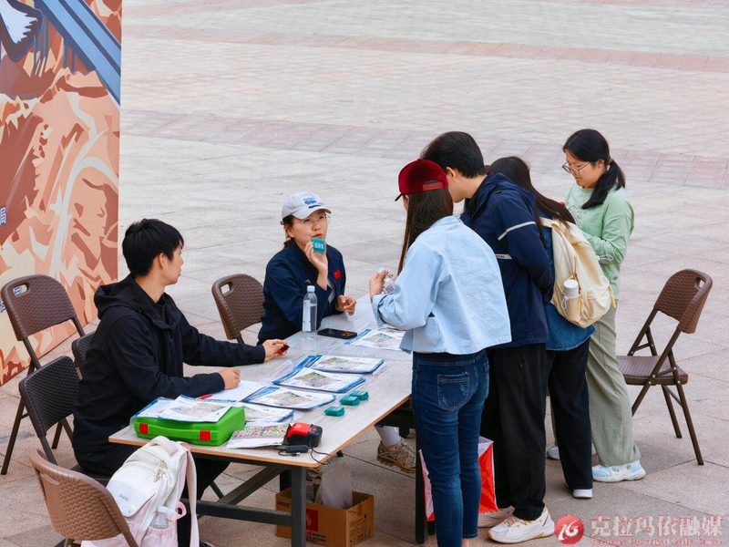 选手在咨询台咨询赛事信息，工作人员耐心讲解。
