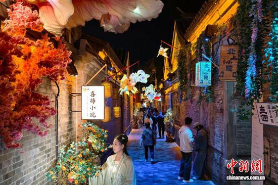 10月5日晚，市民和游客在天津杨柳青古镇街巷打卡游玩。中新社记者 佟郁 摄