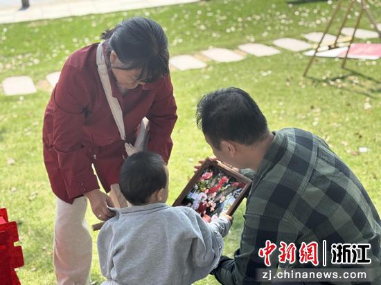 图为：务工人员观看全家福照片。中新社发 镇工轩 供图