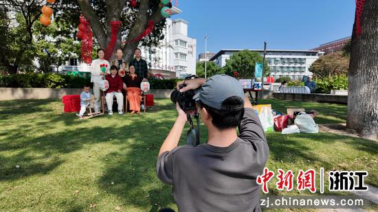 图为：工作人员为务工人员拍摄全家福。中新社发 镇工轩 供图
