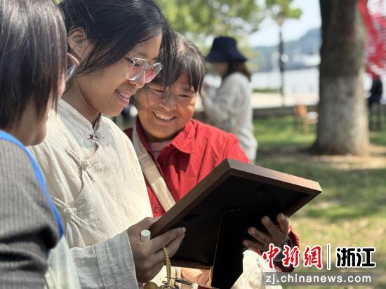图为：看着全家福照片，务工人员脸上洋溢着幸福笑容。中新社发 镇工轩 供图