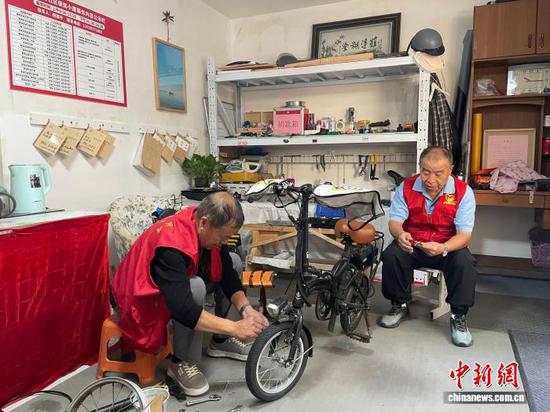图为天津市河西区谊景村社区银发志愿者为邻居维修自行车。记者 江莹 摄