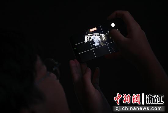  图为：学生拍摄无人机呈现的“商行天下”。中新社记者 王刚 摄