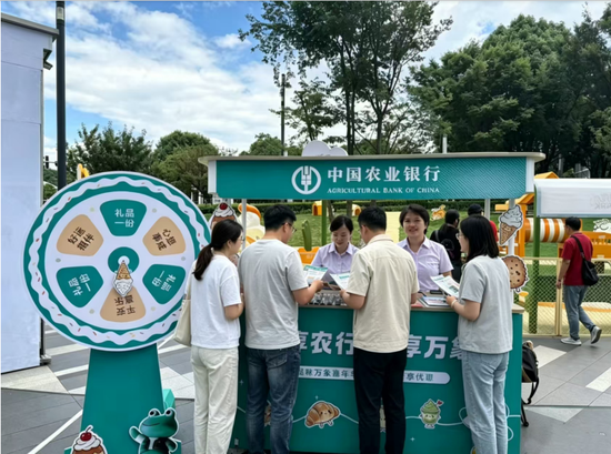 图为农行工作人员为打卡逛市的市民讲解信用卡优惠活动