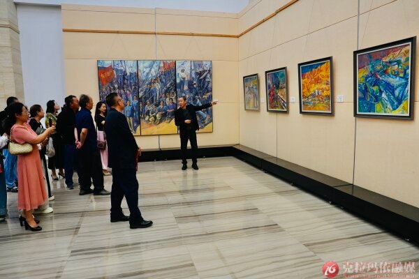 克拉玛依美术馆展厅，油画家为观众介绍画作背后的故事，让参观者在艺术熏陶中感悟城市发展历程。