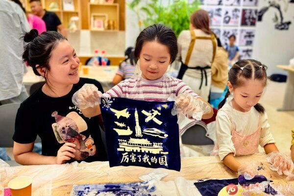 克拉玛依市文化馆非遗体验活动中，小朋友动手体验拓印技艺，当印有“中国梦”字样的作品成型，热爱祖国的种子在童心间悄然萌发。