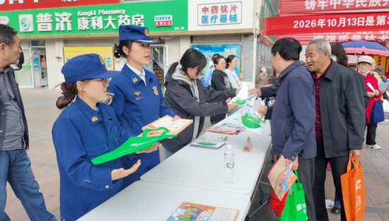 消防宣传员面向群众分发消防宣传单。向欣欣摄