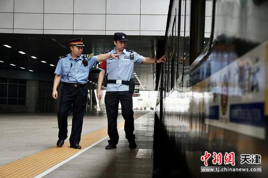 图为北京铁路公安局天津公安处乘警支队民警在发车前对列车车底进行安全检查。（北京铁路公安局天津公安处供图）
