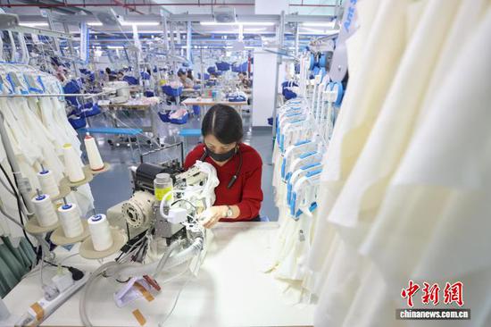 10月14日，在贵州省都匀市绿茵湖轻纺产业园内，多家服装企业依托智能吊挂、数据管控等数字化设备组织生产。中新社记者 瞿宏伦 摄