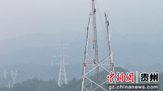 施工人员攀爬铁塔进行组立作业。