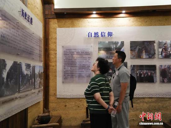10月16日，2名游客在贵州省荔波县瑶山古寨的村史馆参观。中新社记者 周燕玲 摄