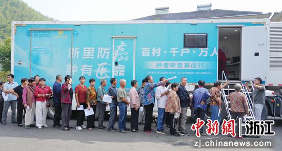 村民在肿瘤筛查车前排队检查。&nbsp;新川村&nbsp;供图