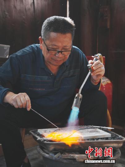 10月19日，贵州省雷山县西江镇麻料村，村里的银匠师在制作苗族银饰。中新社记者 周燕玲 摄