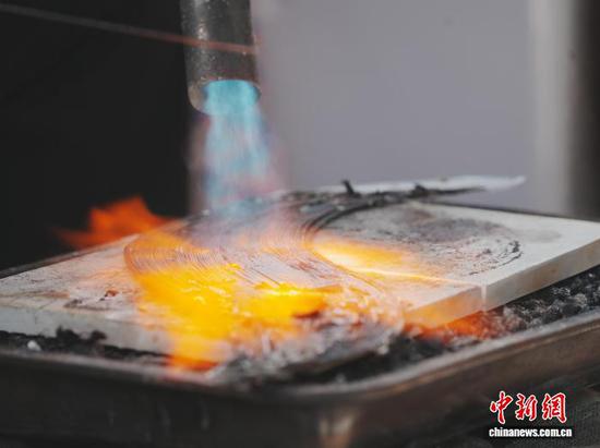 10月19日，贵州省雷山县西江镇麻料村，村里的银匠师在制作苗族银饰。中新社记者 周燕玲 摄