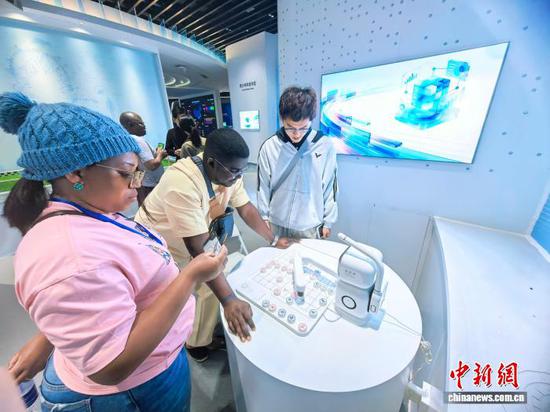 10月20日，来自非洲法语国家等的记者、编辑赴贵州省贵阳市参访。图为参访人员与机器人下象棋。记者张伟摄