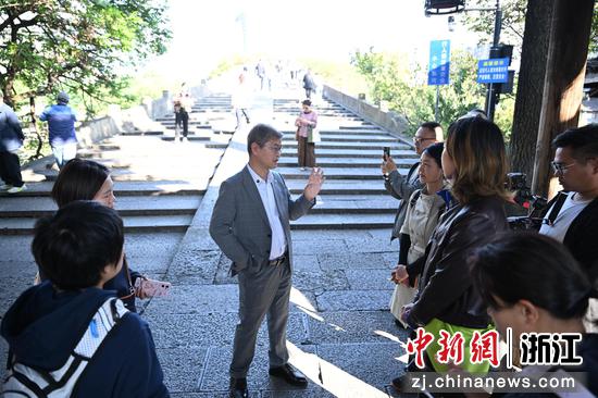 图为：浙江农林大学茶学与茶文化学院教授周新华在拱宸桥边为市民讲解。王刚 摄