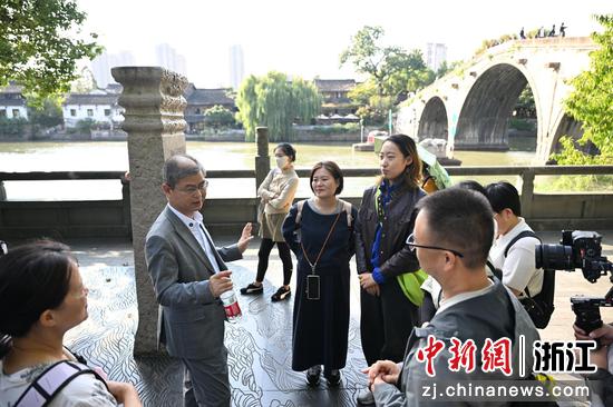 图为：浙江农林大学茶学与茶文化学院教授周新华在拱宸桥边为市民讲解。王刚 摄