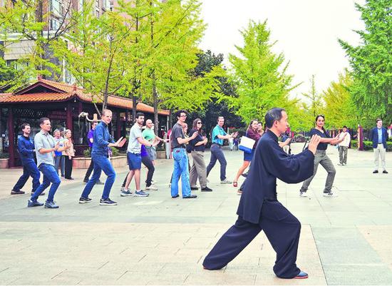在贵州省贵阳市观山湖区金元社区，美国青年们跟着中国老人学习打太极。