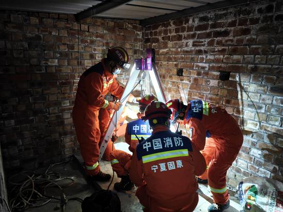 消防救援人员采用三脚架绳索提拉救援方案。