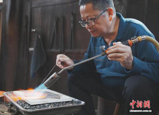 10月19日，李光海在贵州省雷山县西江镇麻料村制作银饰。中新社记者 周燕玲 摄
