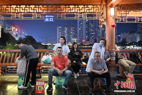 图为10月14日，民众在贵州都匀的西山大桥上体验按摩。中新社记者 张瑶 摄
