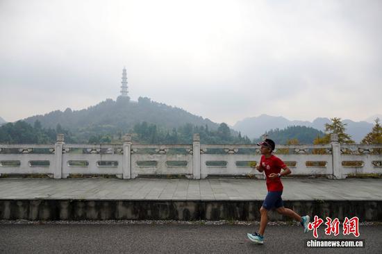 图为10月14日，在贵州都匀绿博园，游客边跑步边欣赏沿途美景。中新社记者 赵梦阳 摄