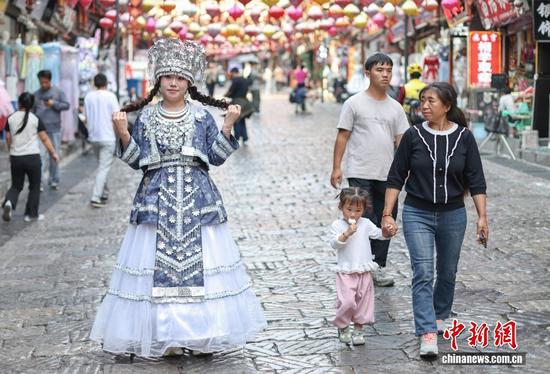图为10月14日，贵州都匀，年轻人在石板古街上拍摄照片。中新社记者 泱波 摄