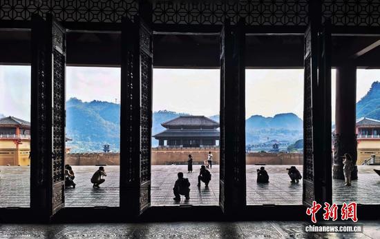 图为10月14日，摄影爱好者们纷纷按下快门，定格都匀秦汉影视城古风建筑群的别样景致。