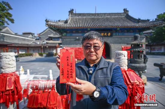10月23日，天津天后宫，台湾退役海军少校、前“新江舰”舰长吕礼诗向记者展示写在祈福牌上的祝福语。　中新社记者 佟郁 摄