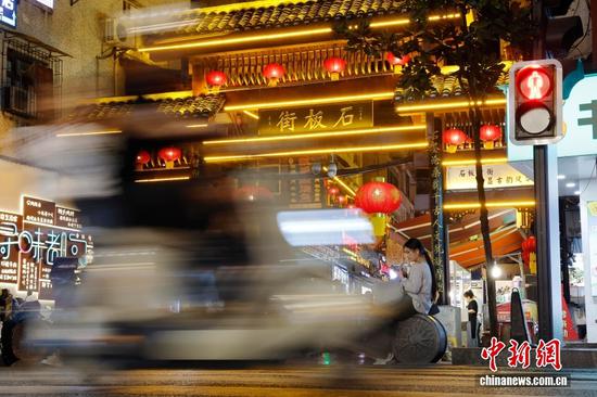 图为10月14日，市民在都匀市石板街路口休息。中新社记者 殷立勤 摄
