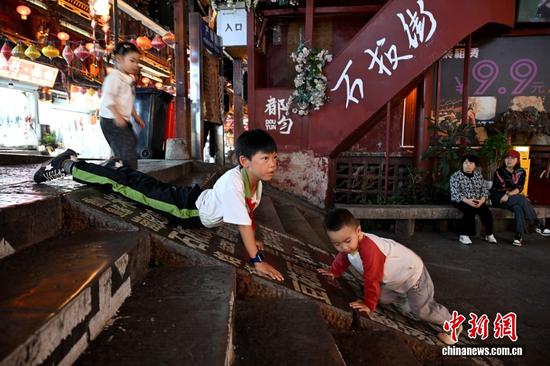 图为10月14日，贵州都匀，小朋友在石板街玩耍。中新社记者 吕明 摄