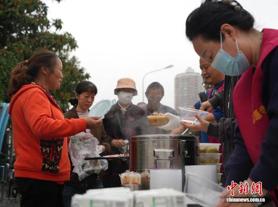 图为10月27日翟饶和志愿者（右一）一起为重病患者及家属免费送午餐。中新社记者 周燕玲 摄