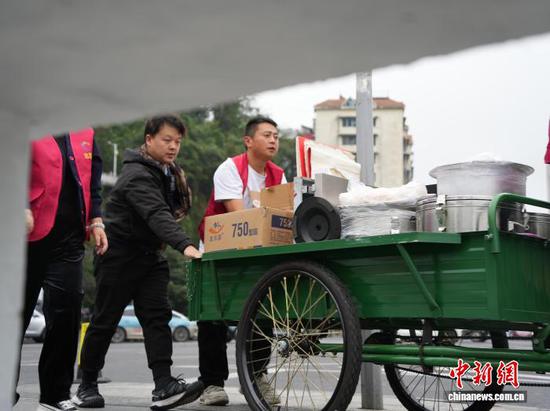 图为10月27日志愿者帮助翟饶和熊泽珲一起送餐。中新社记者 周燕玲 摄