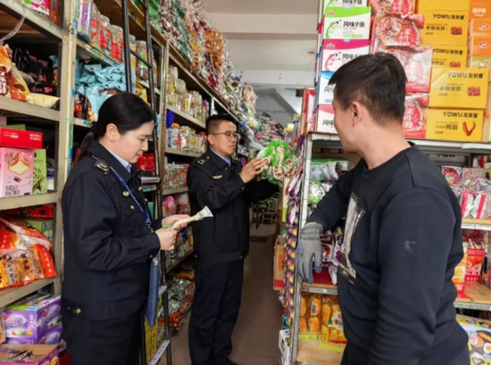 执法人员现场检查副食经营门店。