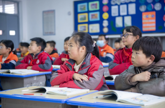 孩子们坐在温暖的教室内上课。