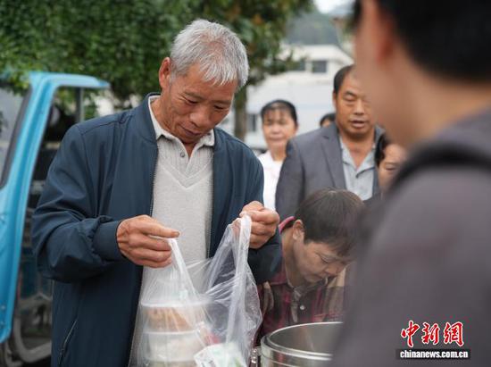 图为10月27日患者家属领到免费的午餐。中新社记者 周燕玲 摄