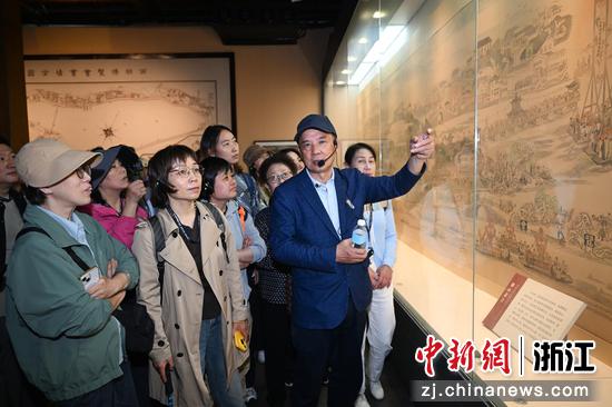 图为：仲向平向活动参与者介绍西湖博览会。王刚 摄