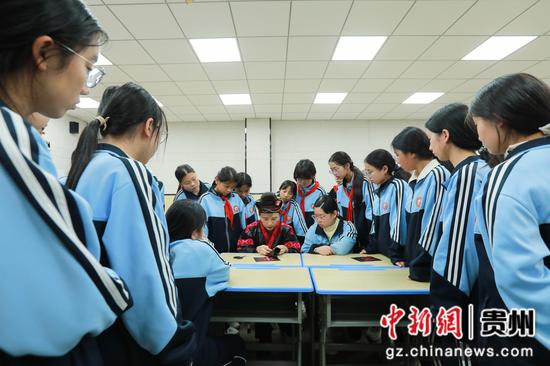 10月27日，省级代表性传承人杨丽在剑河县第五中学社团教室与学生交流苗族刺绣（红绣）技艺。