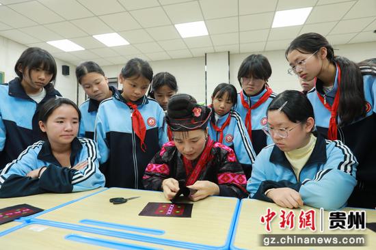 10月27日，省级代表性传承人杨丽在剑河县第五中学社团教室与学生交流苗族刺绣（红绣）技艺。